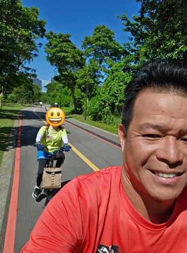 A coach selfie with a learner riding behind on a park connector