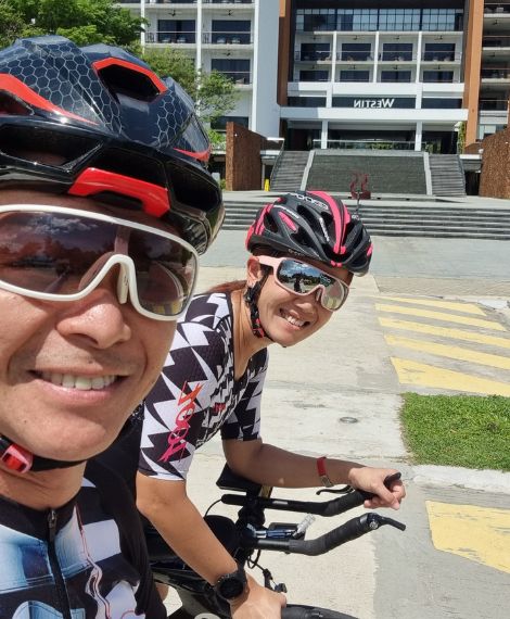 Two road cyclists in kit and helmets, a selfie on a ride